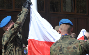 Dwóch żołnierzy Wojska Polskiego wiesza flagę RP na maszcie